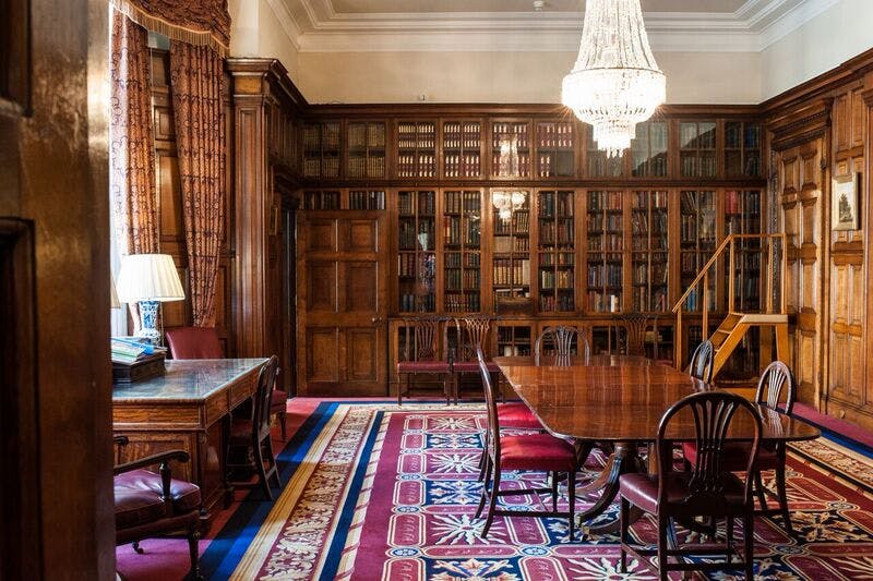 Elegant meeting space in Merchant Taylors' Hall with wooden paneling and chandelier.