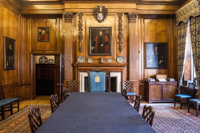 Merchant Taylors' Hall courtroom with wooden paneling, ideal for formal meetings and events.