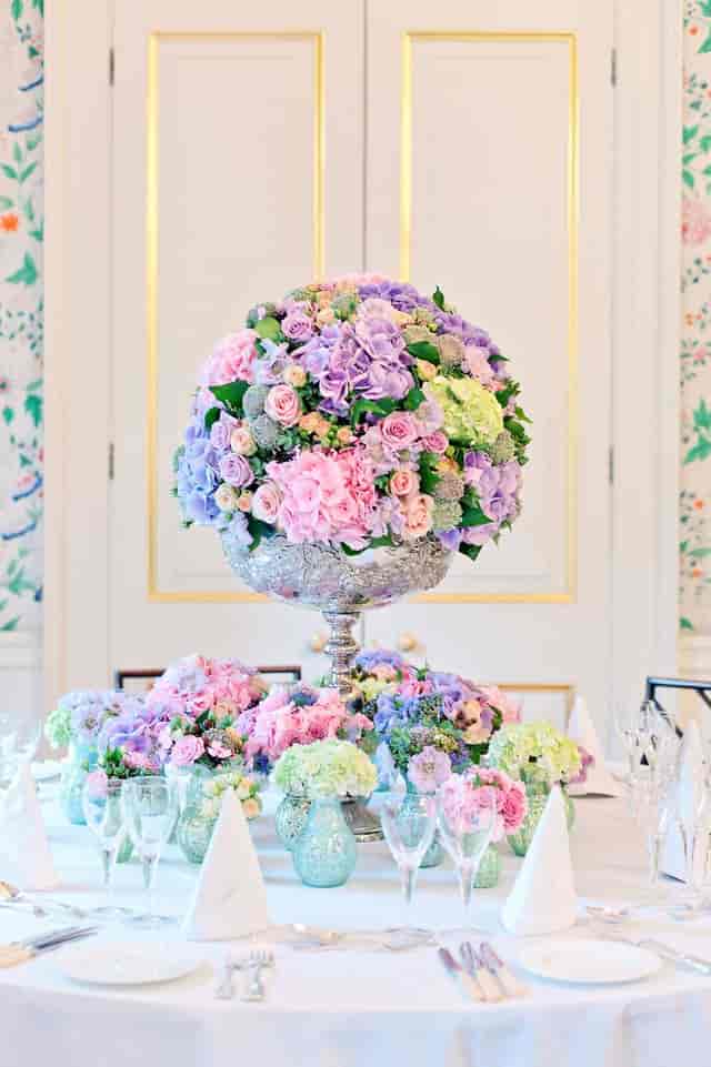 Elegant floral centerpiece of pastel roses in silver urn at Merchant Taylors' Hall.