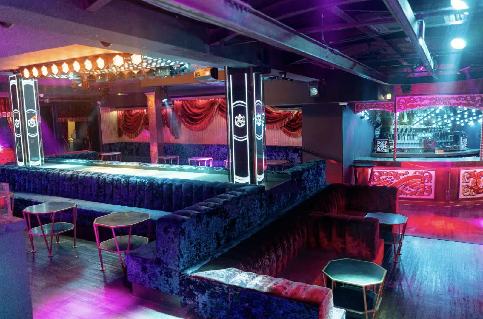 Stylish event space with plush seating and vibrant lighting for upscale nightlife events.