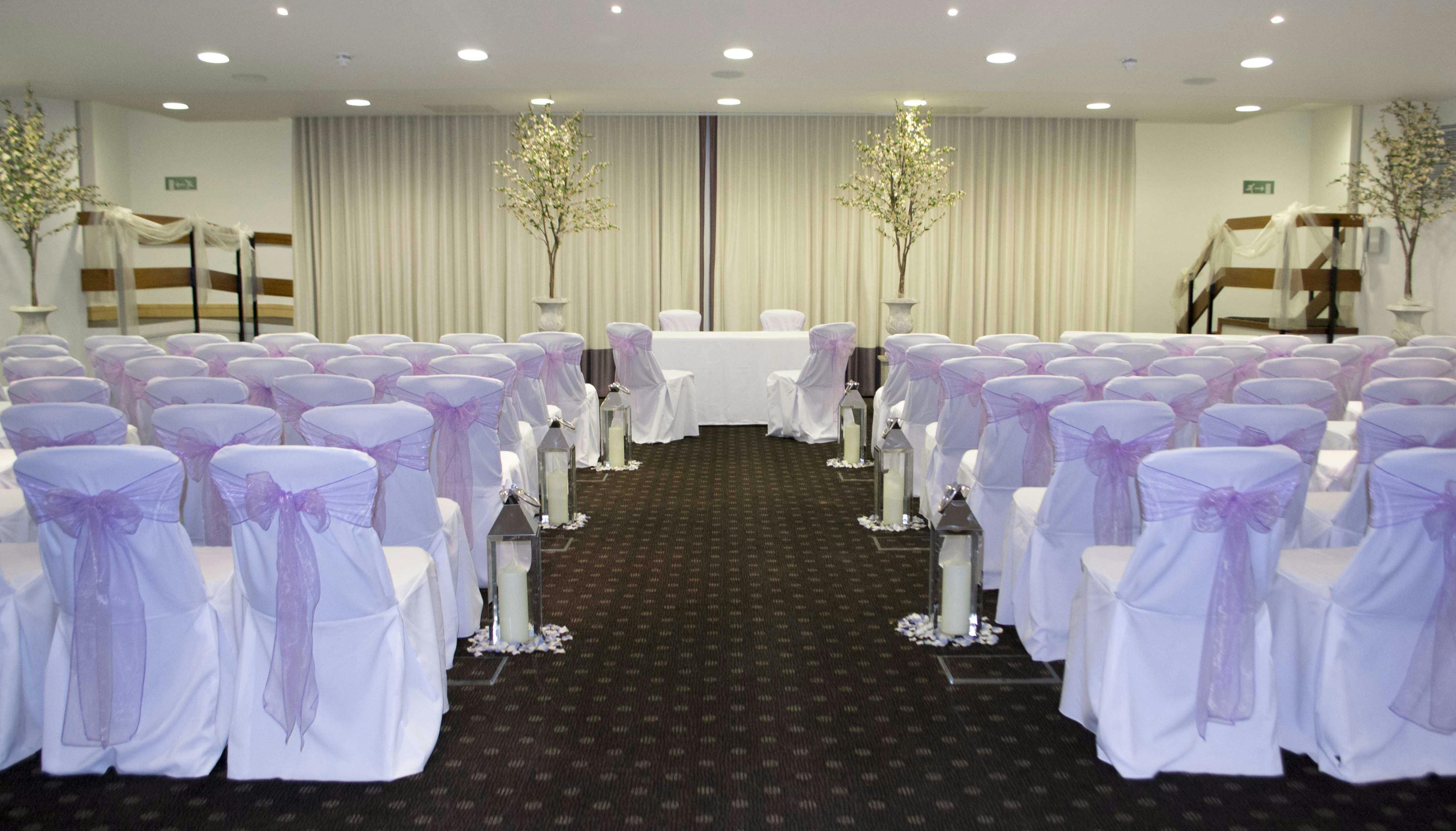 Beaumont Room at The Lensbury, elegant wedding venue with lavender sashes and soft lighting.