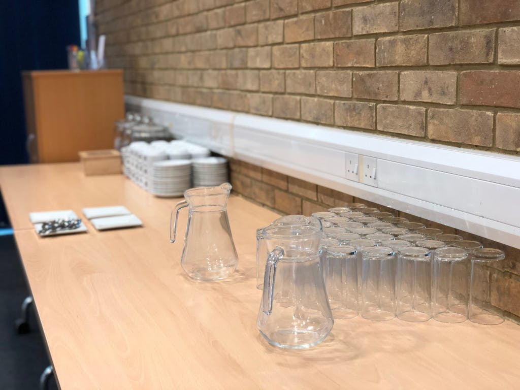 Conference room refreshment station with glass pitchers for meetings at Capability House.