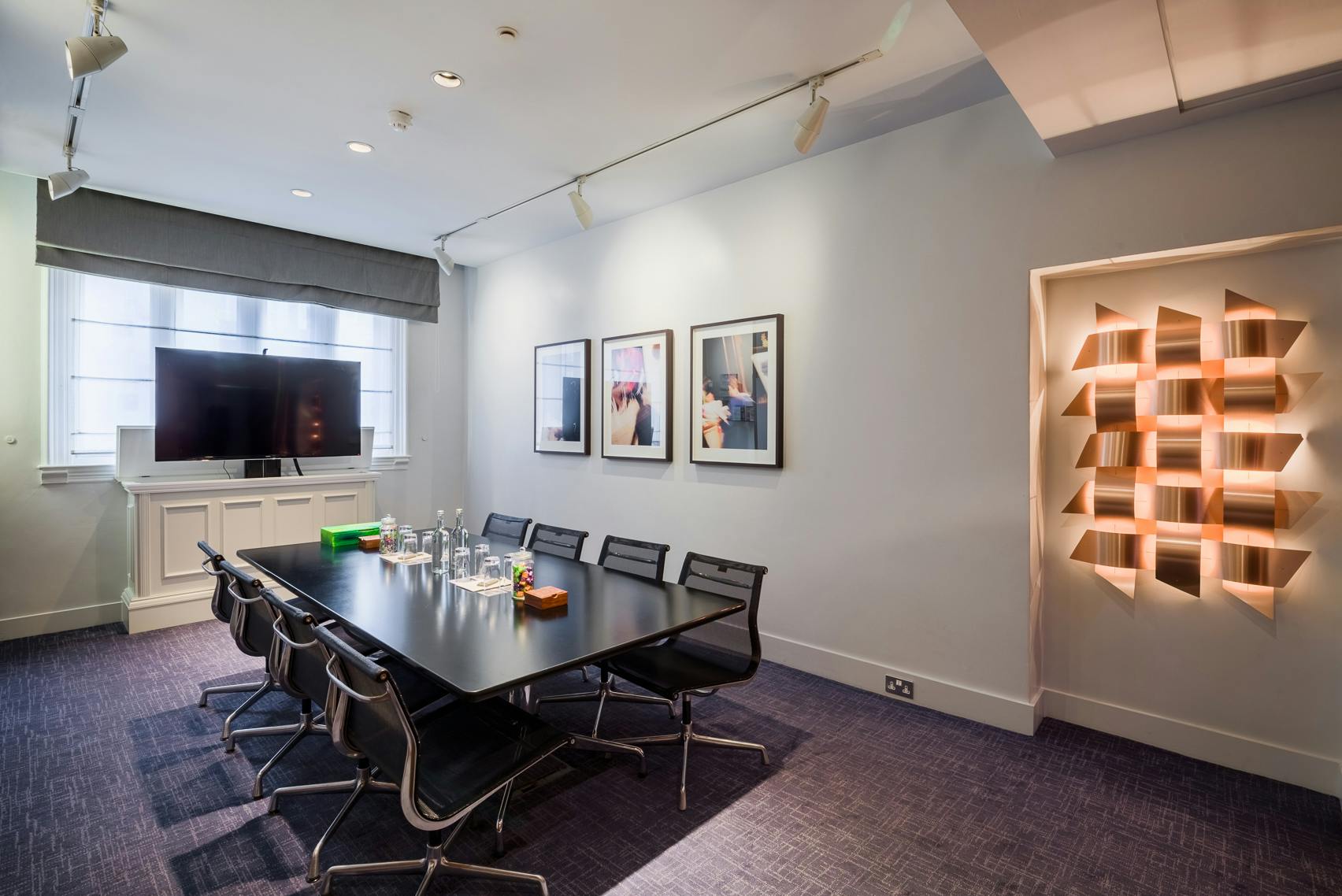 Modern meeting room in Andaz London, featuring a sleek table and large presentation screen.