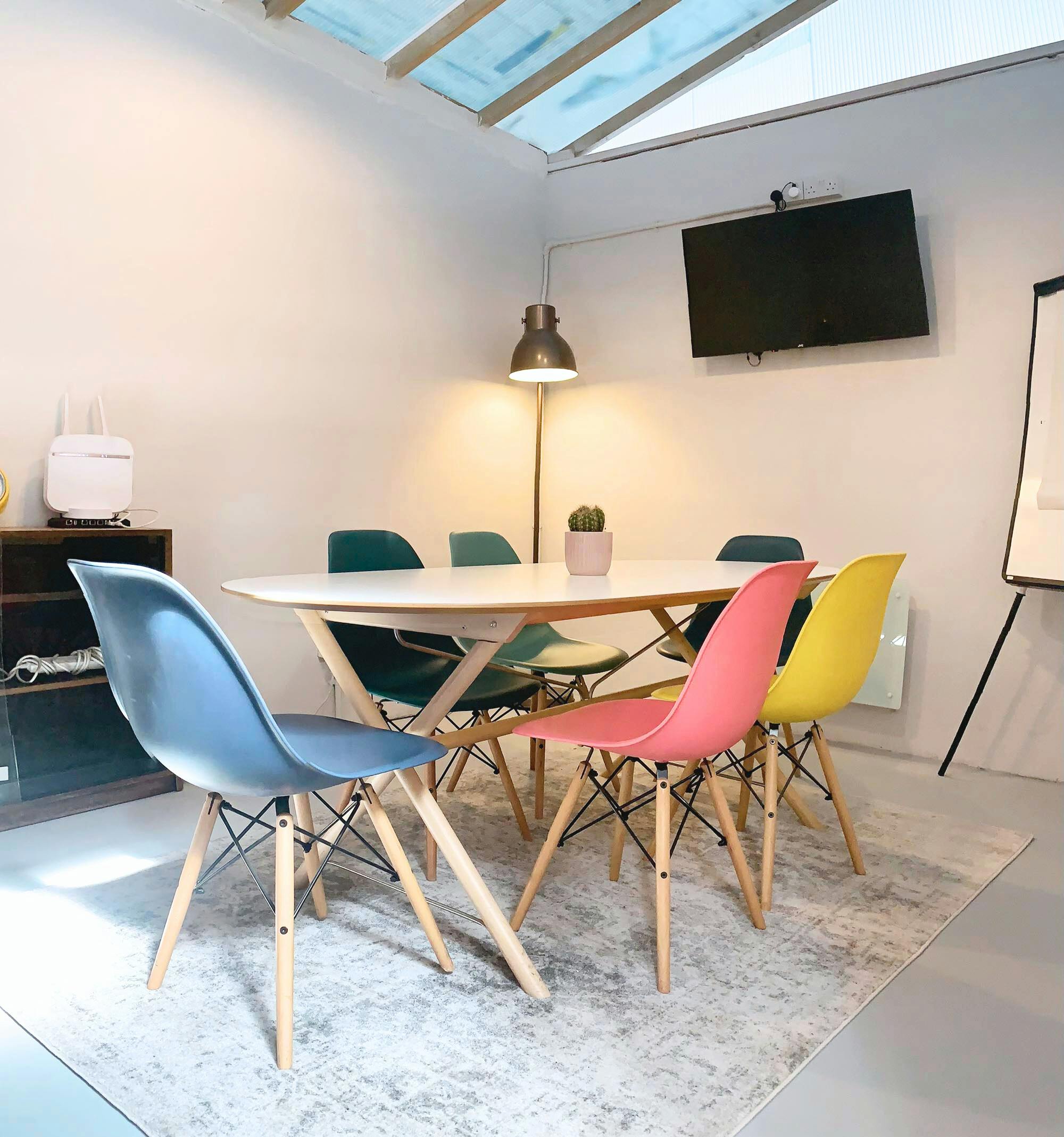 Modern ARK coworking meeting room with colorful chairs, ideal for brainstorming sessions.