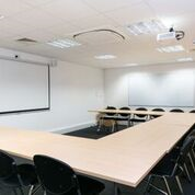 Versatile Pinnacle House meeting room with U-shaped table for workshops and strategic meetings.