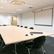 Modern meeting room with large table and ergonomic chairs for productive discussions.