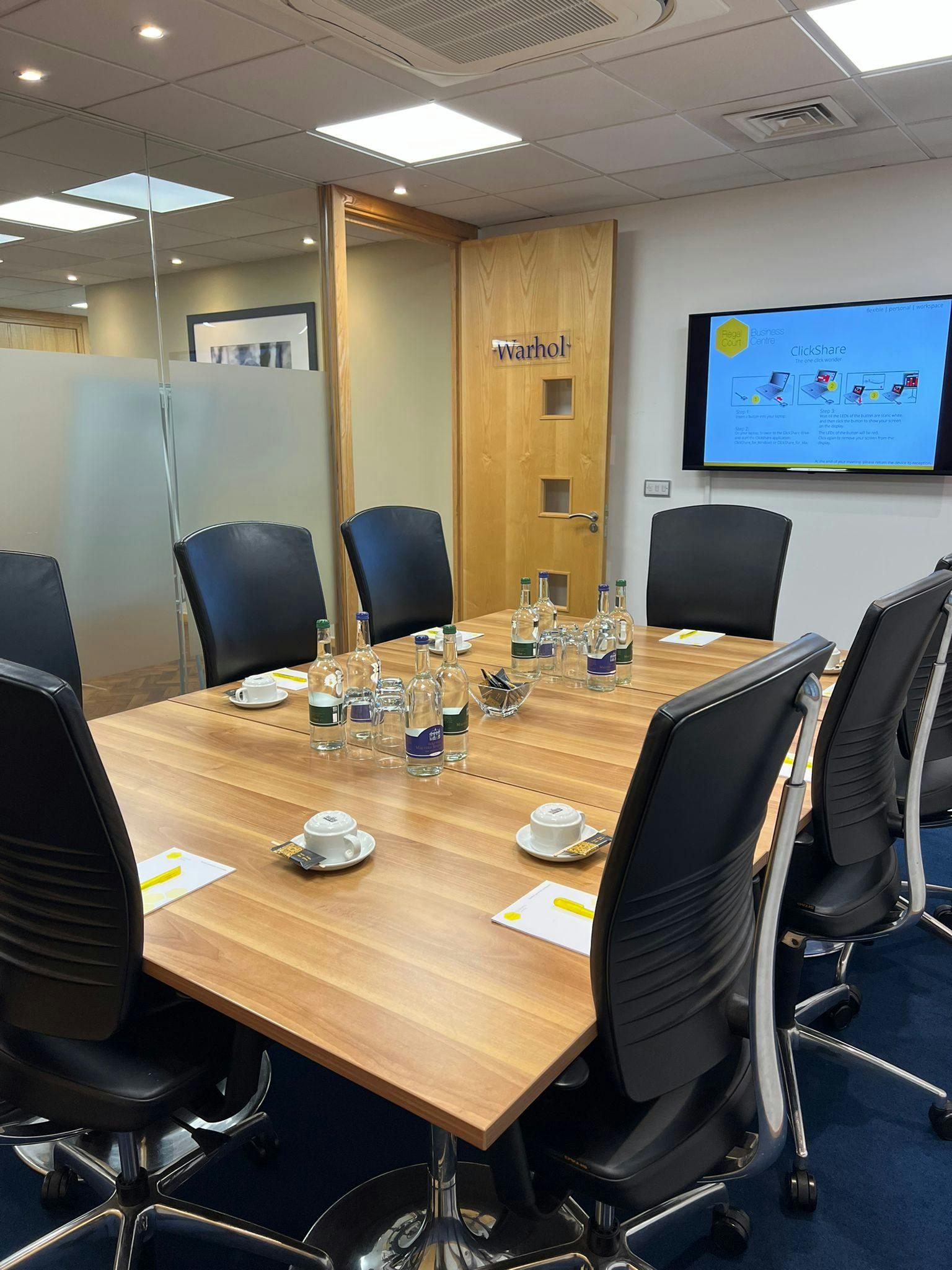 "Warhol in Regal Court meeting room with polished table, ready for professional collaboration."