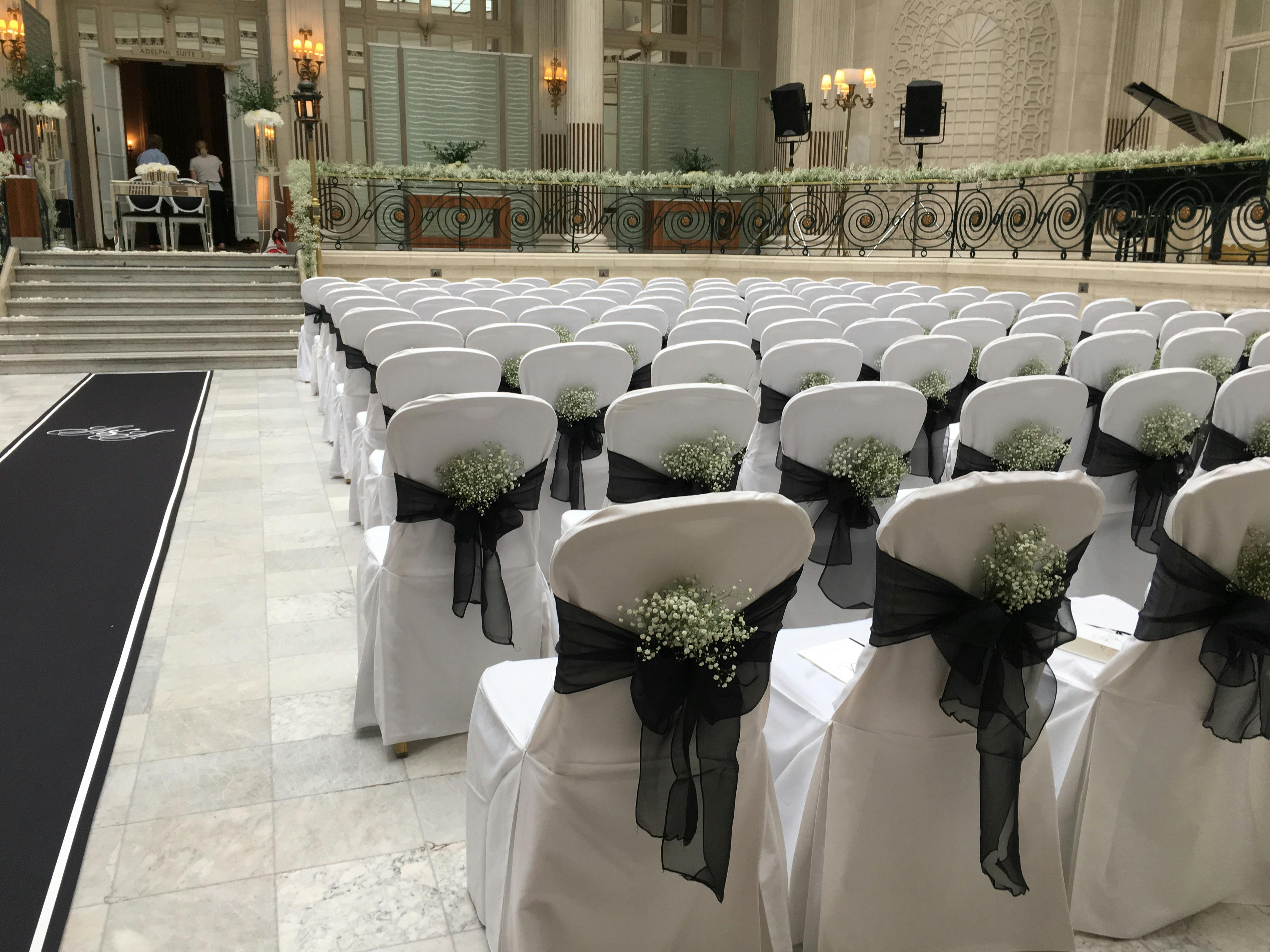 Adelphi Suite at The Waldorf Hilton, London: elegant wedding venue with white chairs and floral decor.