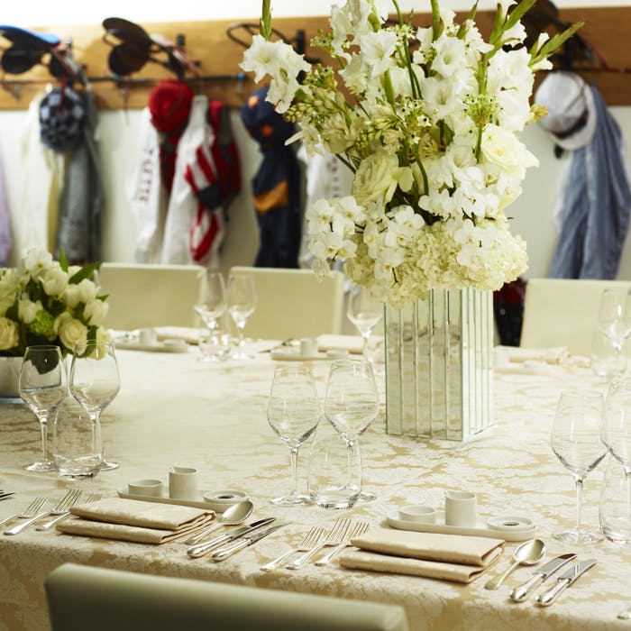 Elegant table with floral centerpiece in Ascot Racecourse's Jockeys' Weighing Room event.