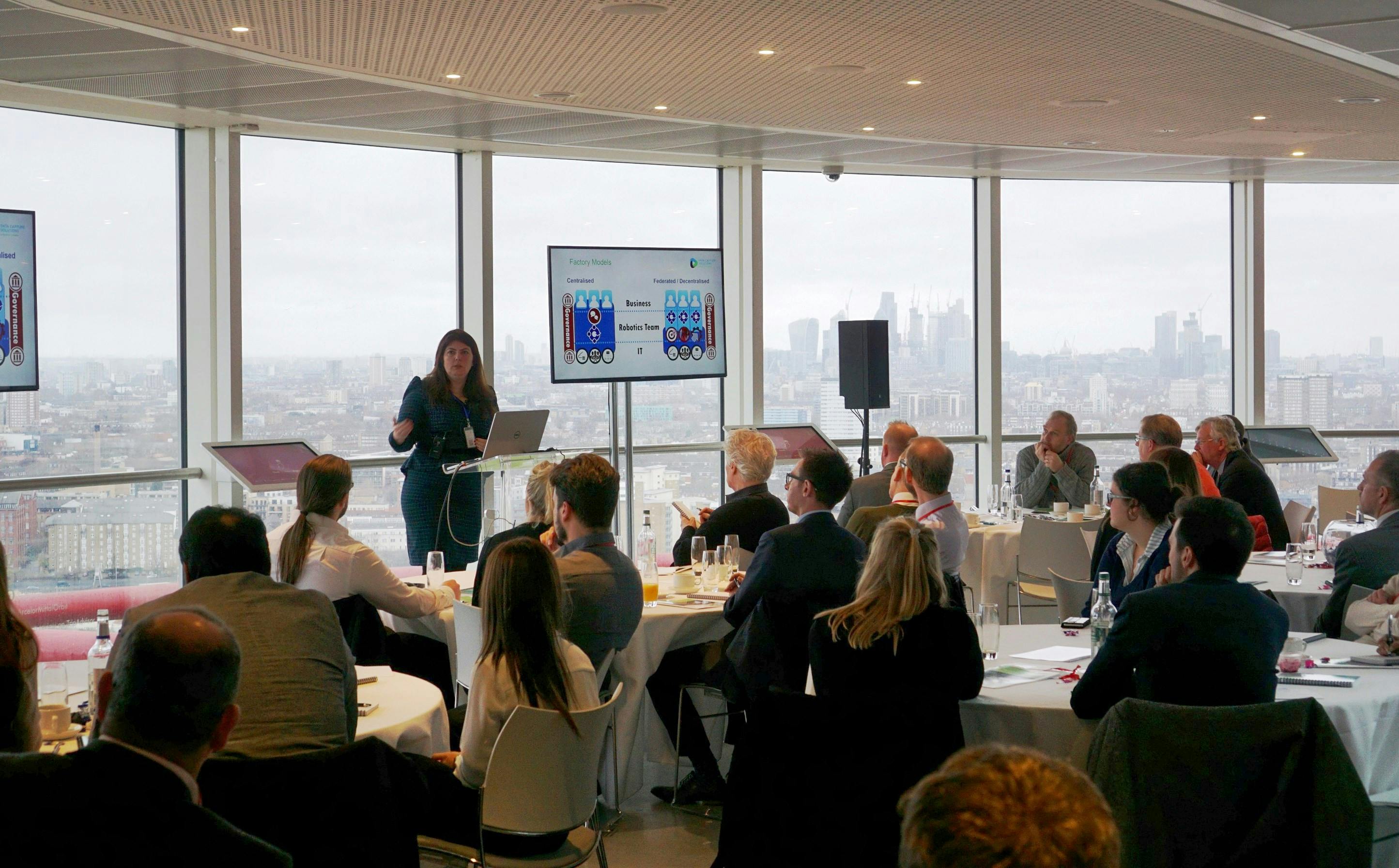 Corporate event at ArcelorMittal Orbit with speaker and panoramic city view.