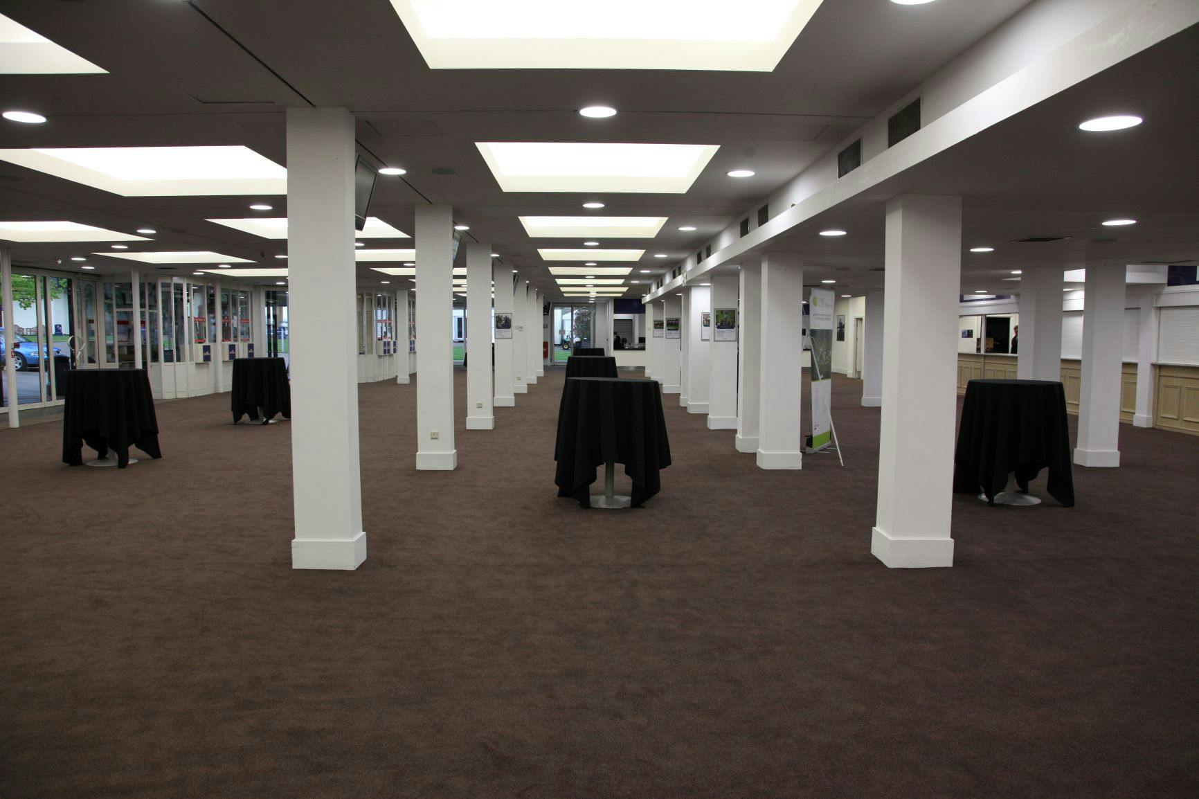 Ascot Racecourse Exhibition Hall: modern venue with cocktail tables for events and receptions.