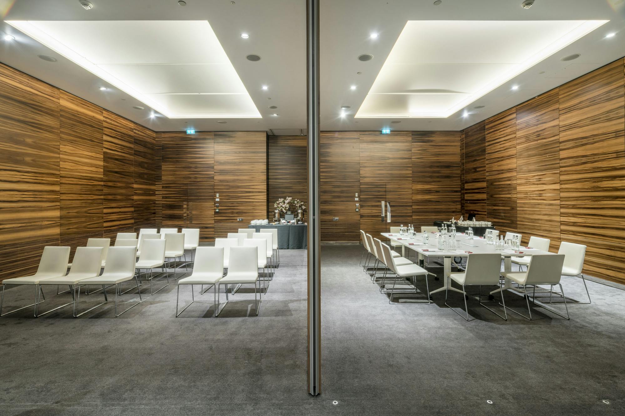 Versatile meeting space in ME London with wooden paneling for events and presentations.