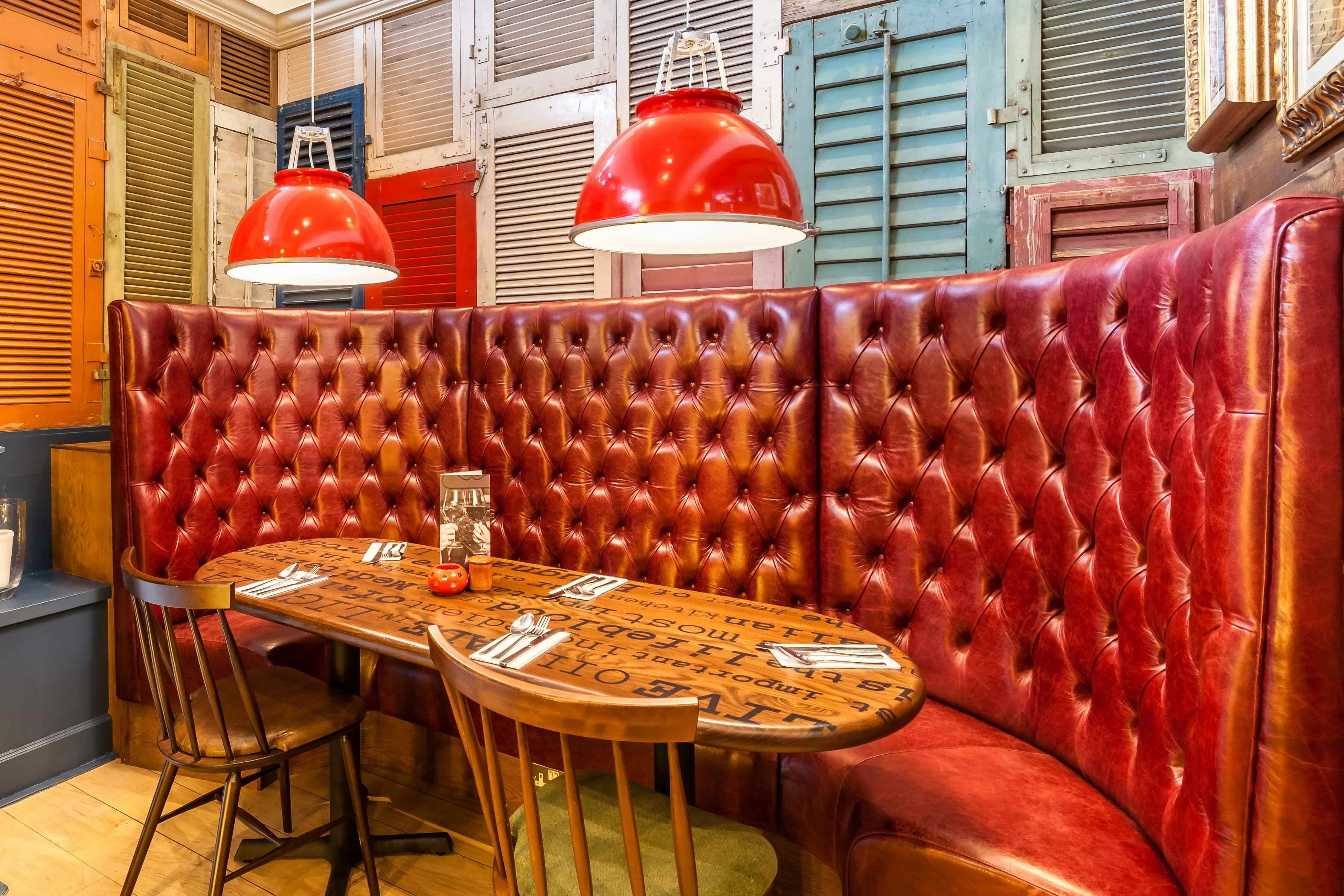 Cozy dining space with red leather seating at The Sorrento Room, ideal for meetings and gatherings.