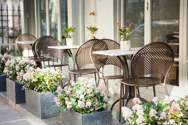 Outdoor café at Trishna for casual meetings and networking events with floral planters.