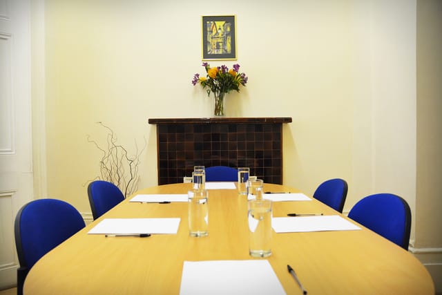 Queensborough Meeting Room with wooden table, ideal for business meetings and events.