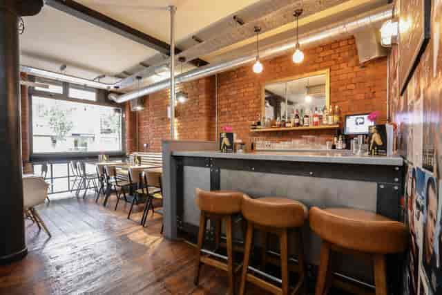 Stylish bar area with exposed brick, perfect for cocktail receptions and networking events.