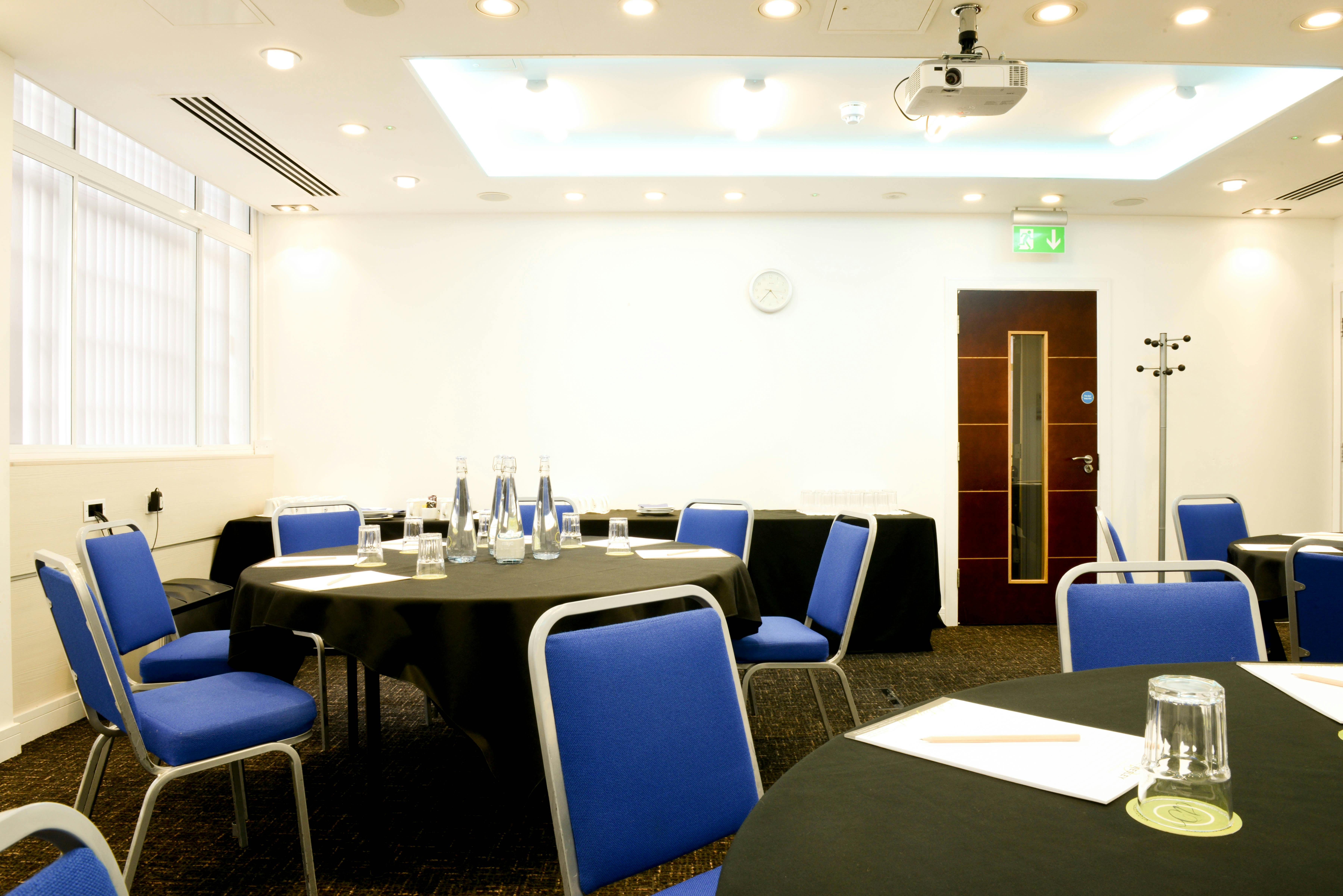 Camden Suite meeting room with round tables, ideal for conferences and workshops.