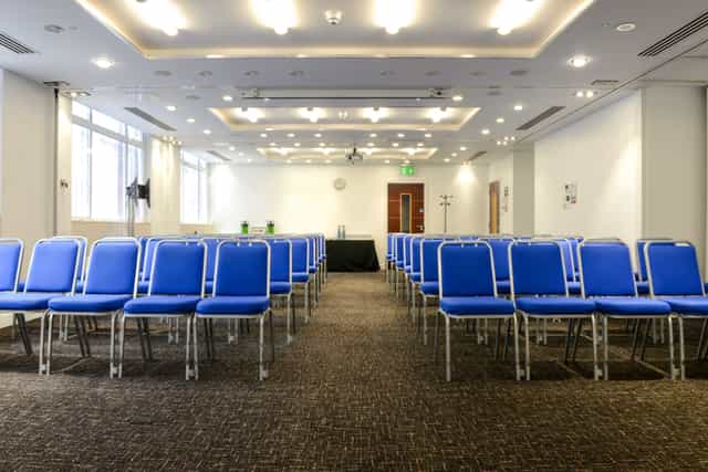 Camden Suite meeting space with blue chairs, ideal for conferences and presentations.