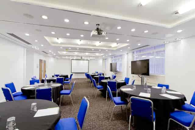 Camden Suite meeting room with round tables, ideal for conferences and presentations.