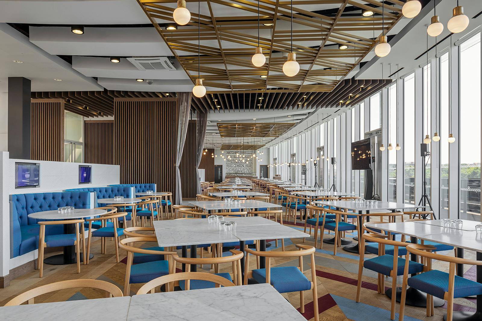 Modern event space in London Stadium with stylish blue seating for networking events.