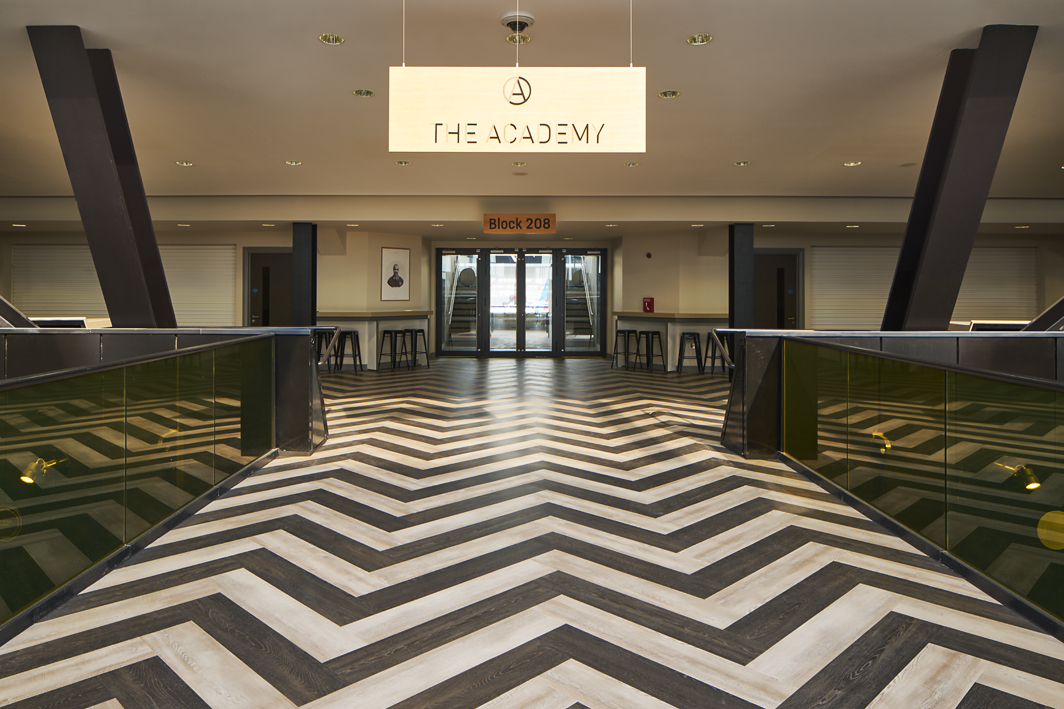 Modern event space in London Stadium with chevron-patterned floor for conferences and gatherings. - Banner