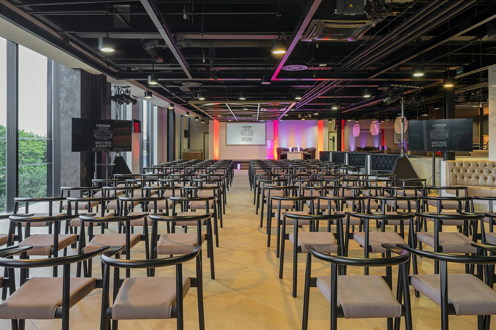 Event space at The Forge, London Stadium, with chairs and stage for corporate meetings.