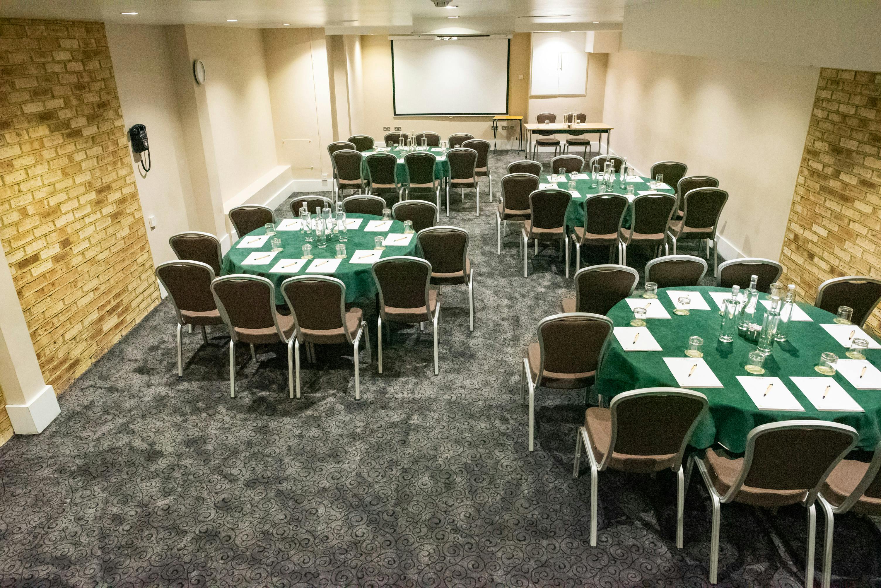 Kings Cross meeting space with green tables, ideal for workshops and conferences.