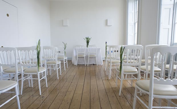 New River Room at Clissold House, minimalist meeting space with white chairs and floral decor.