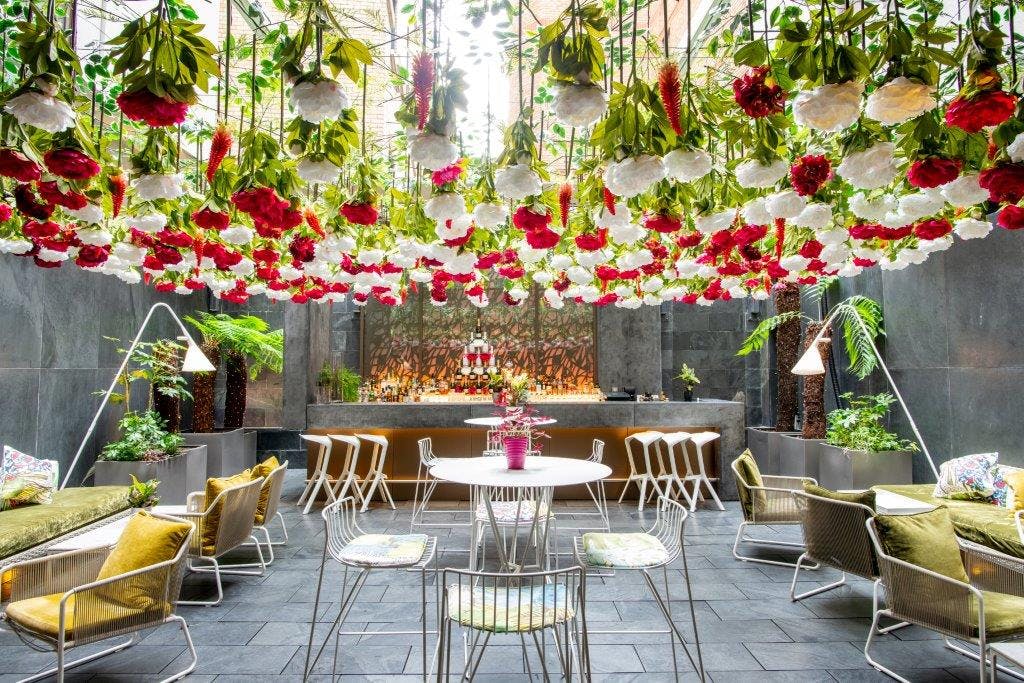 Vibrant Secret Garden event space with floral decor, perfect for networking and gatherings.