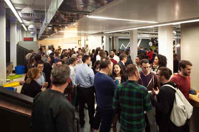 Corporate mixer at Huckletree AlphaBeta auditorium, open-plan event space.