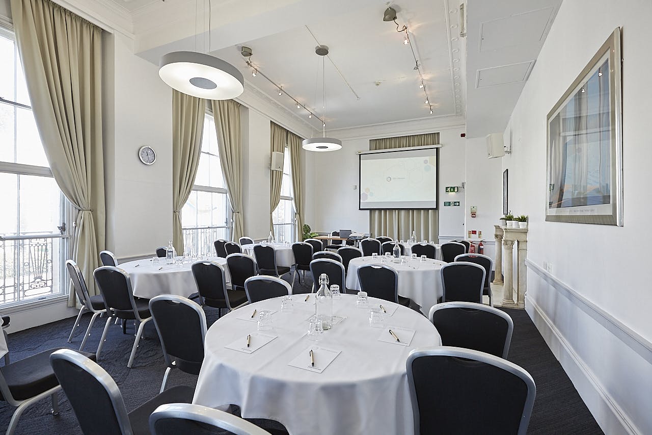 Corporate meeting room with round tables, ideal for workshops and presentations.