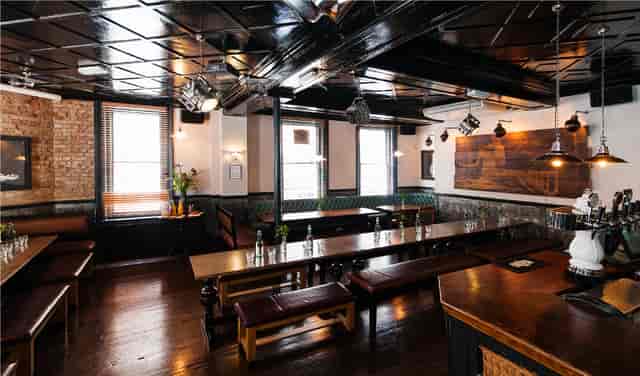 Upstairs Private Bar: rustic modern event space with communal tables for gatherings.