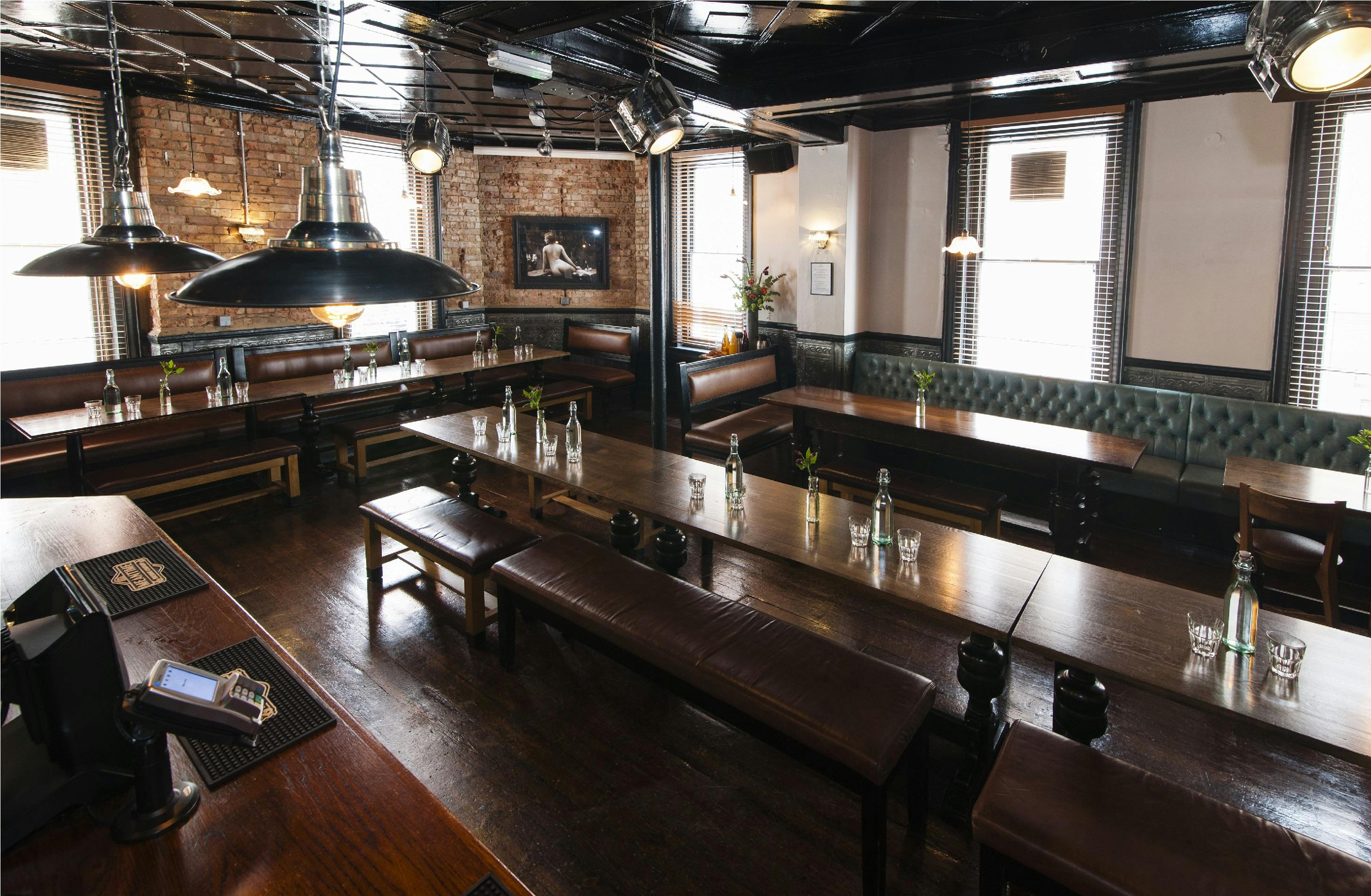 Upstairs Private Bar: industrial-chic event space with communal tables for networking.