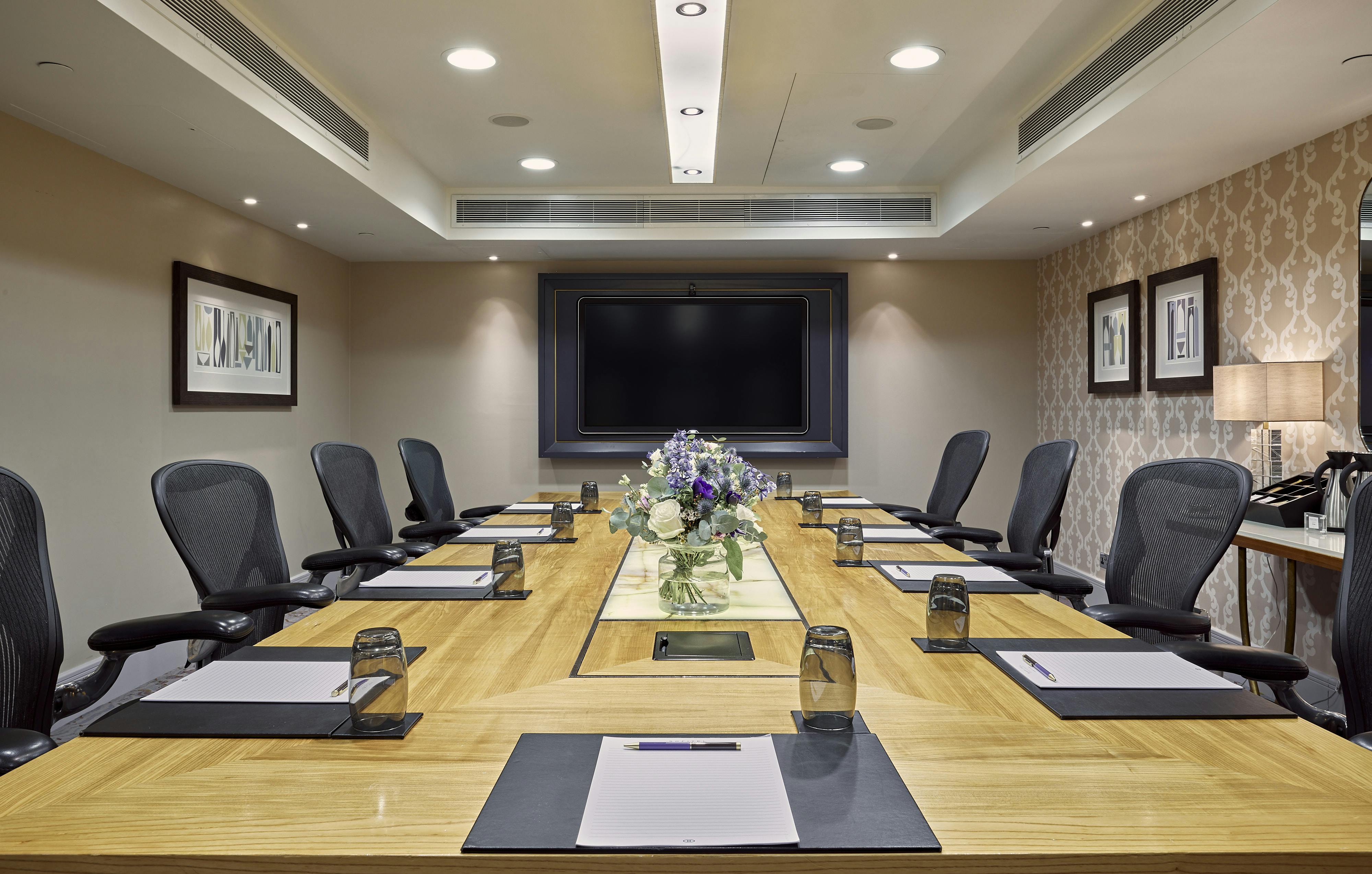 Belgravia conference room at Sofitel London, featuring a long wooden table for meetings.