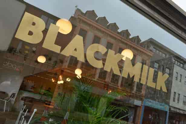 Black Milk Cafe storefront with large windows, perfect for casual meetings and events.