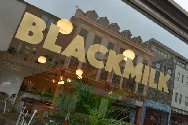 Black Milk Cafe storefront with large windows, perfect for casual meetings and events.