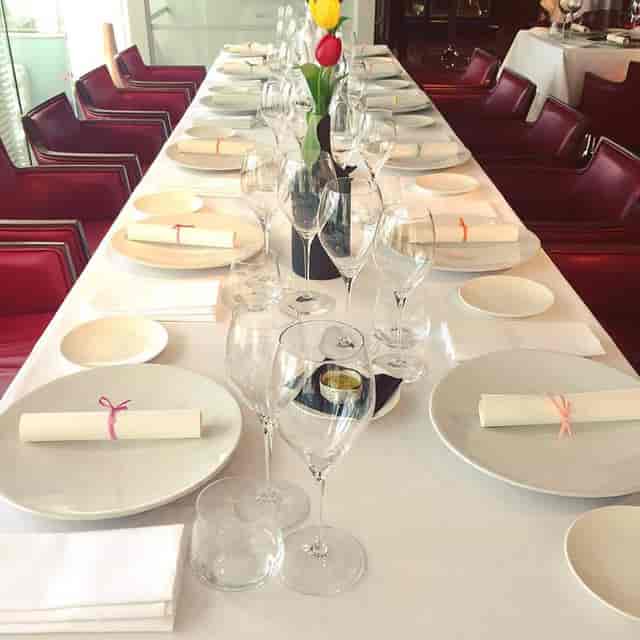 Elegant dining table setup with white linens for corporate events and celebrations.