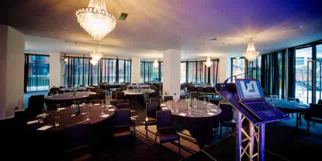Sophisticated conference venue with round tables and natural light at Canalside.