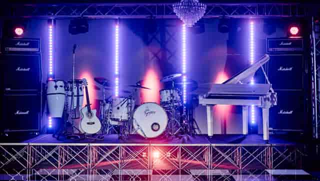 Vibrant stage with grand piano and drum kit at Canalside for live concerts and events.
