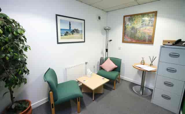 Cozy counselling room with chairs and greenery for informal discussions and meetings.