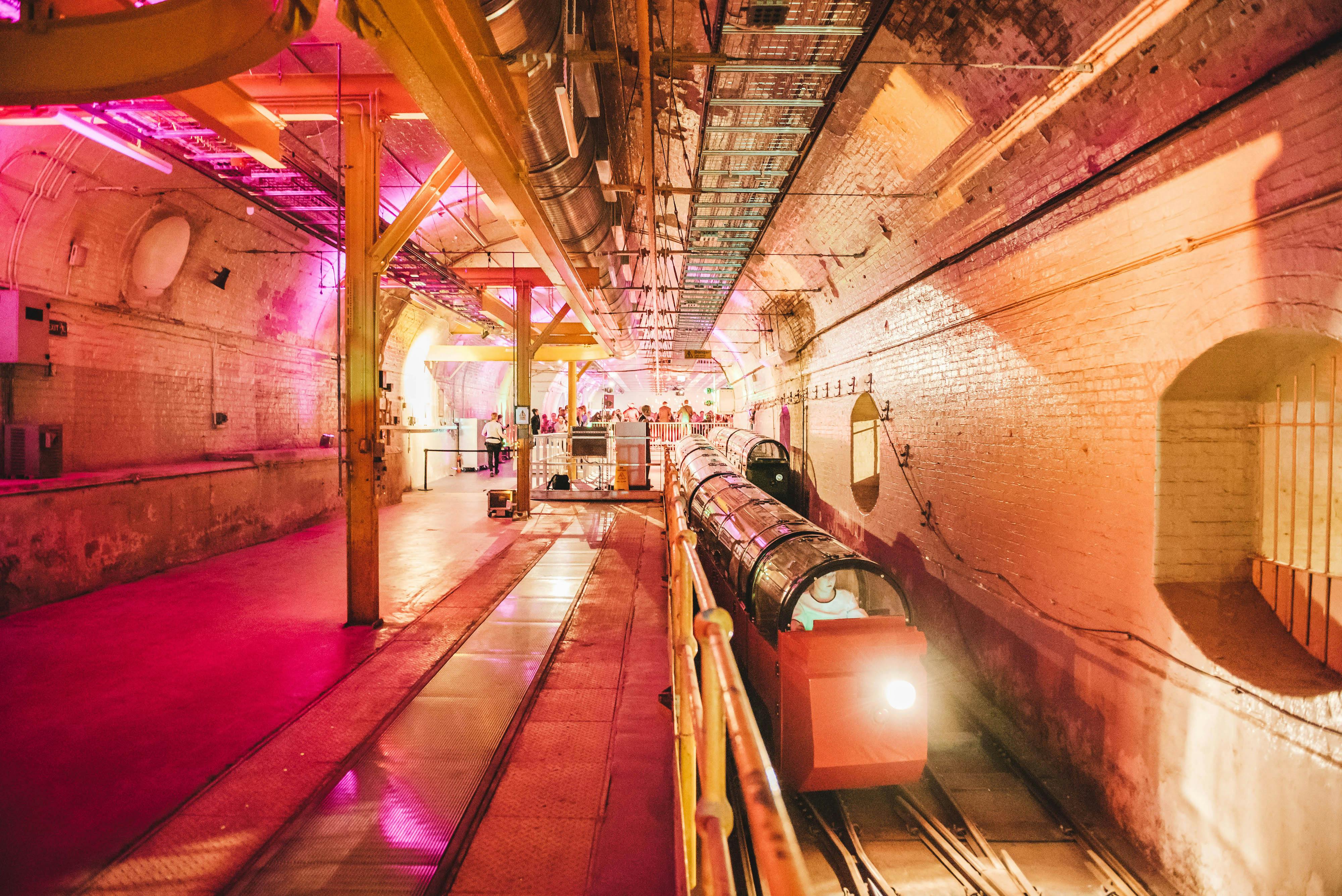 Mail Rail venue with vibrant pink lighting, ideal for events and immersive experiences.