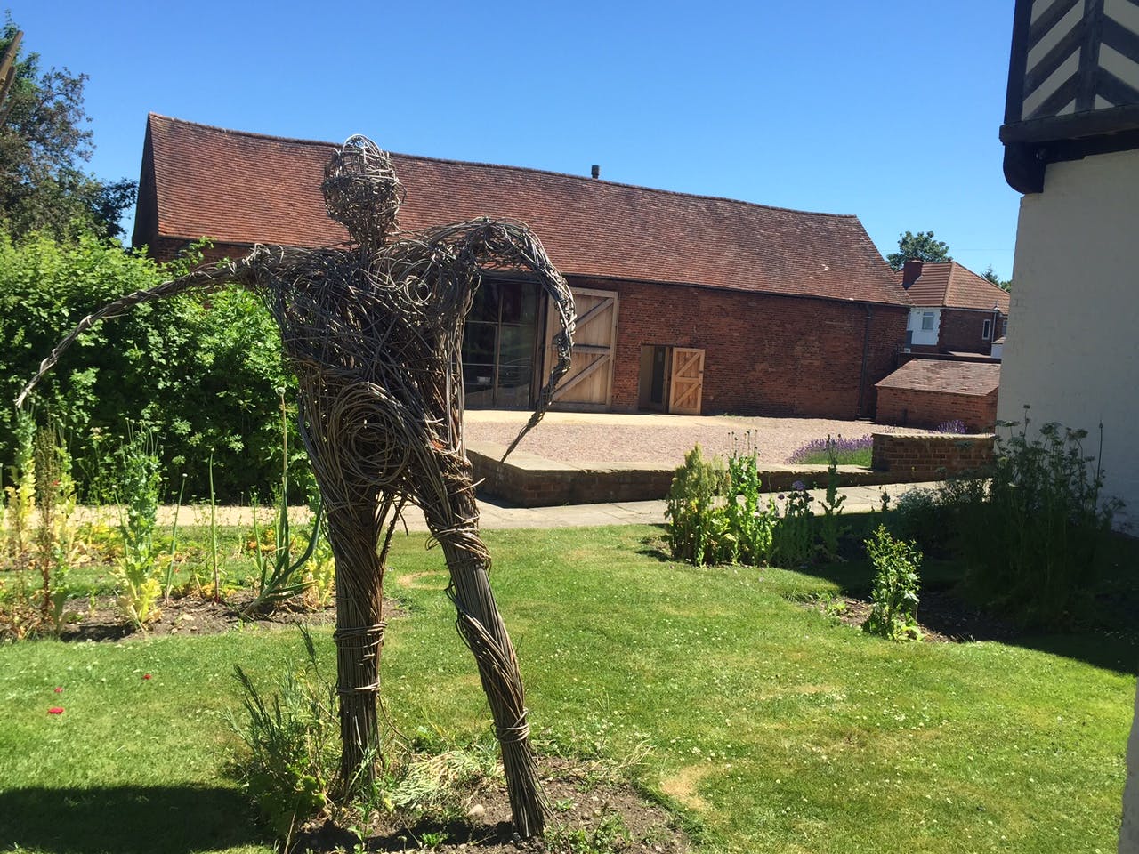 Outdoor sculpture of intertwined branches at Blakesley Hall for events and gatherings.