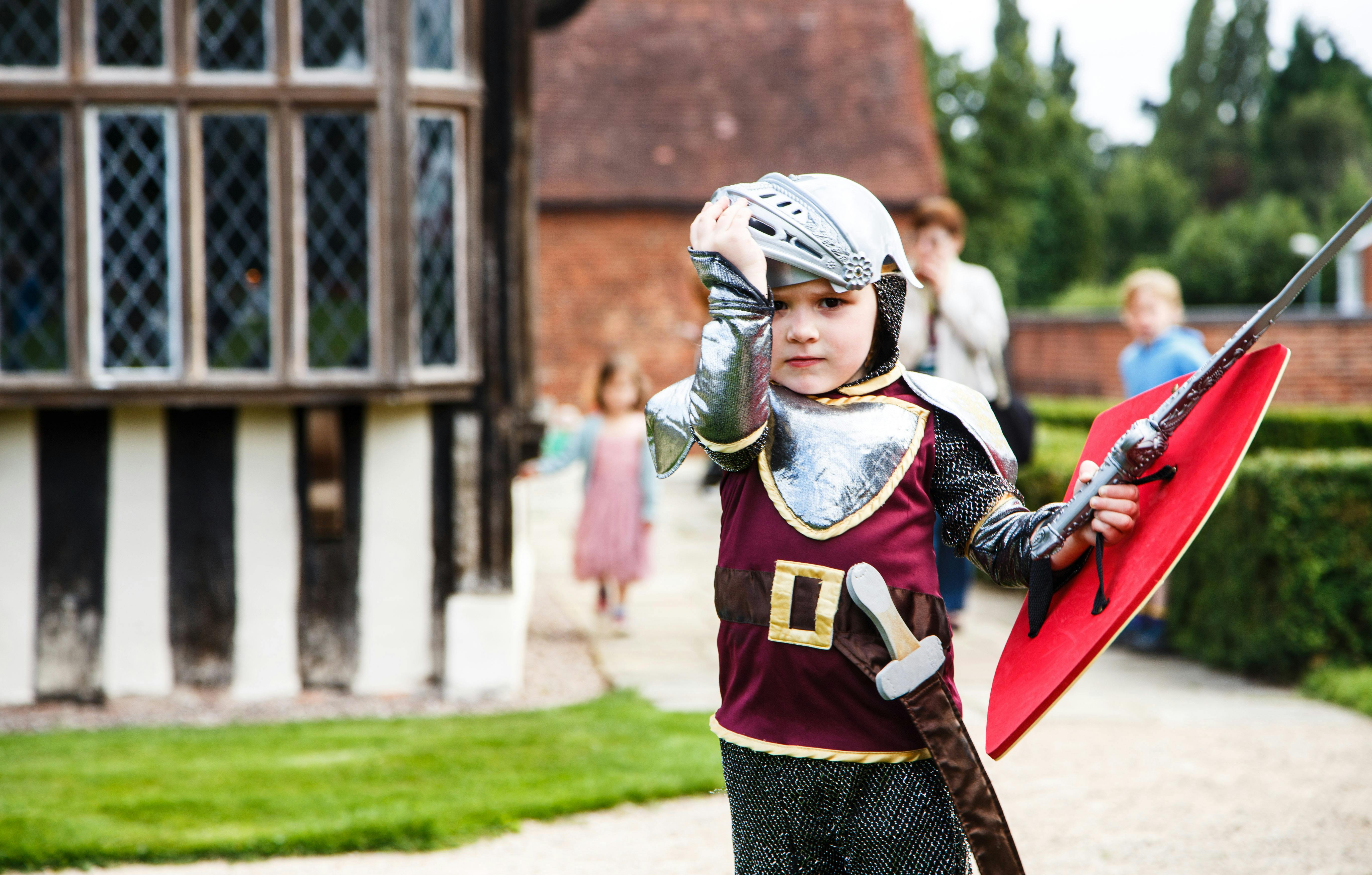 Child in knight costume at Blakesley Hall's Great Hall, perfect for family events.
