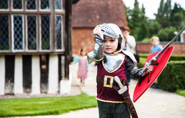 Child in knight costume at Blakesley Hall's Great Hall, perfect for family events.