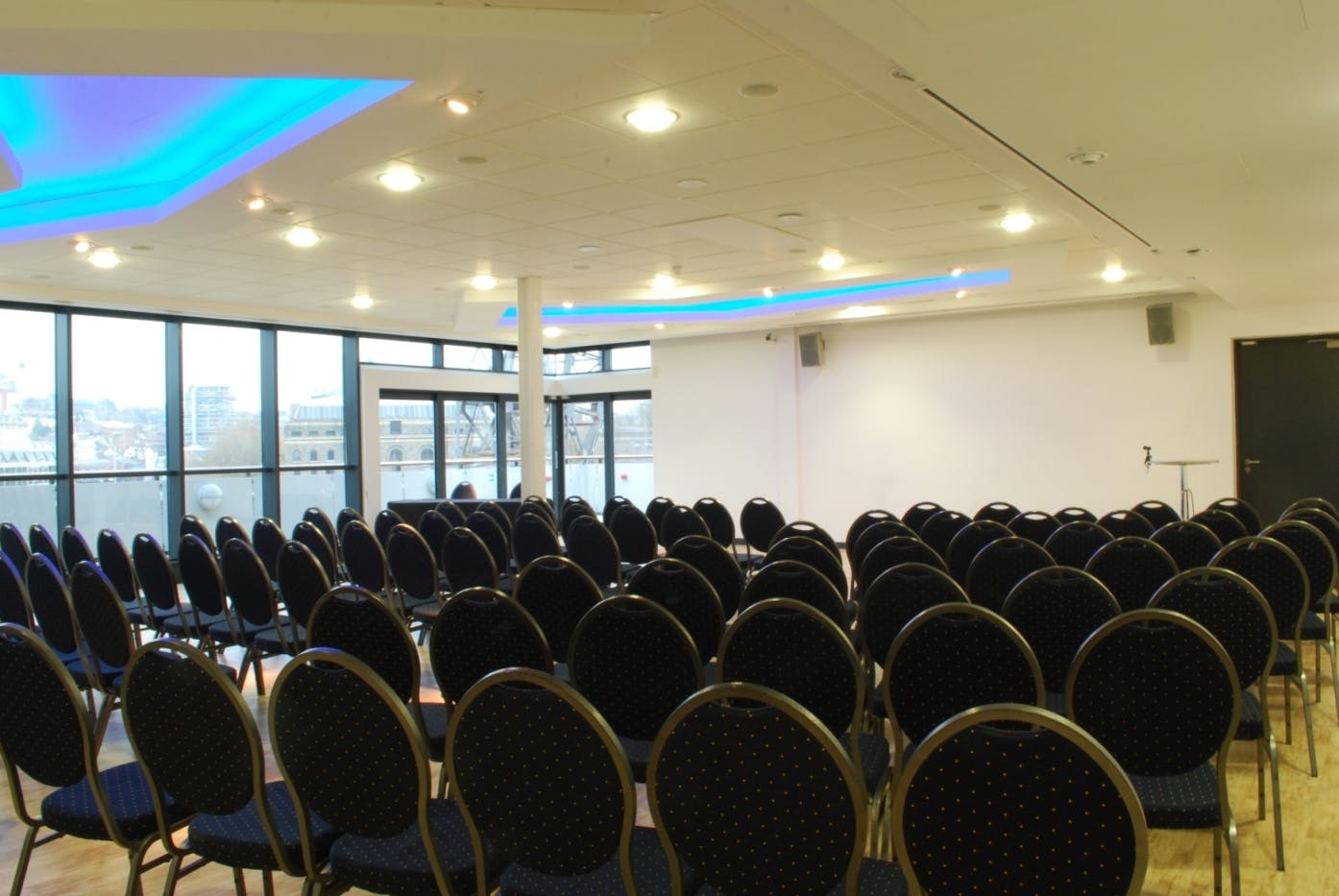 Events Suite in M Shed, modern seminar space with black chairs and blue lighting.