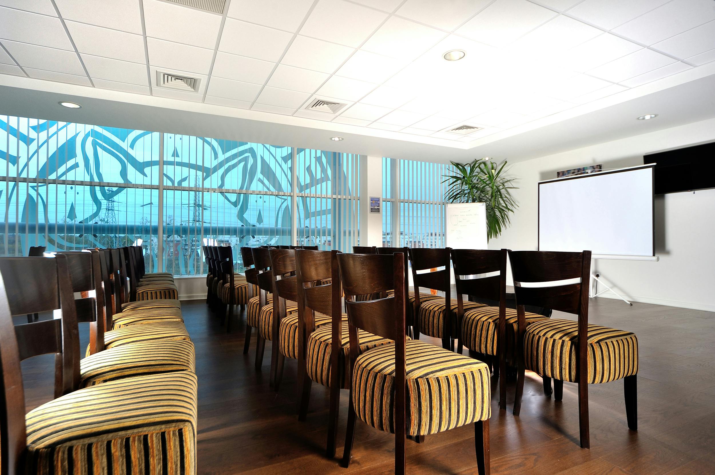 Rowley Suite at Leicester City FC: bright meeting room for workshops with striped chairs.