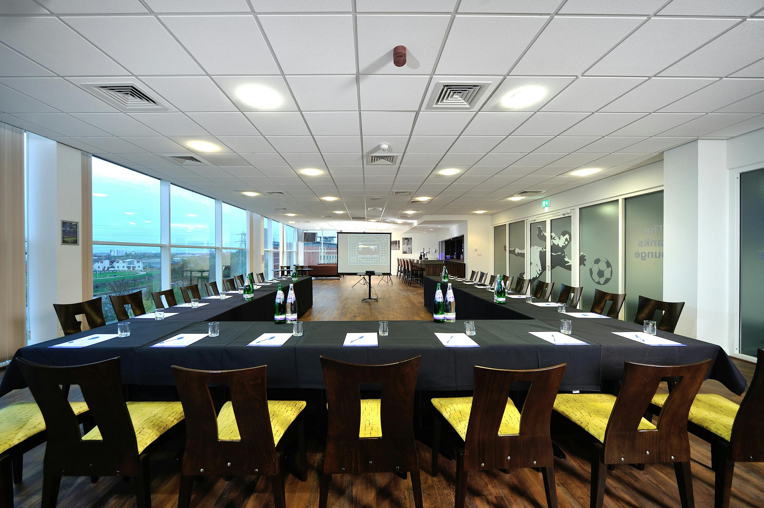 Banks Lounge at Leicester City FC, corporate meeting room with yellow-accented chairs.