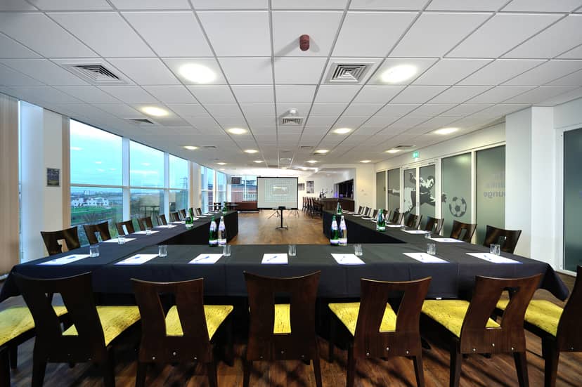 Banks Lounge at Leicester City FC, corporate meeting room with yellow-accented chairs.