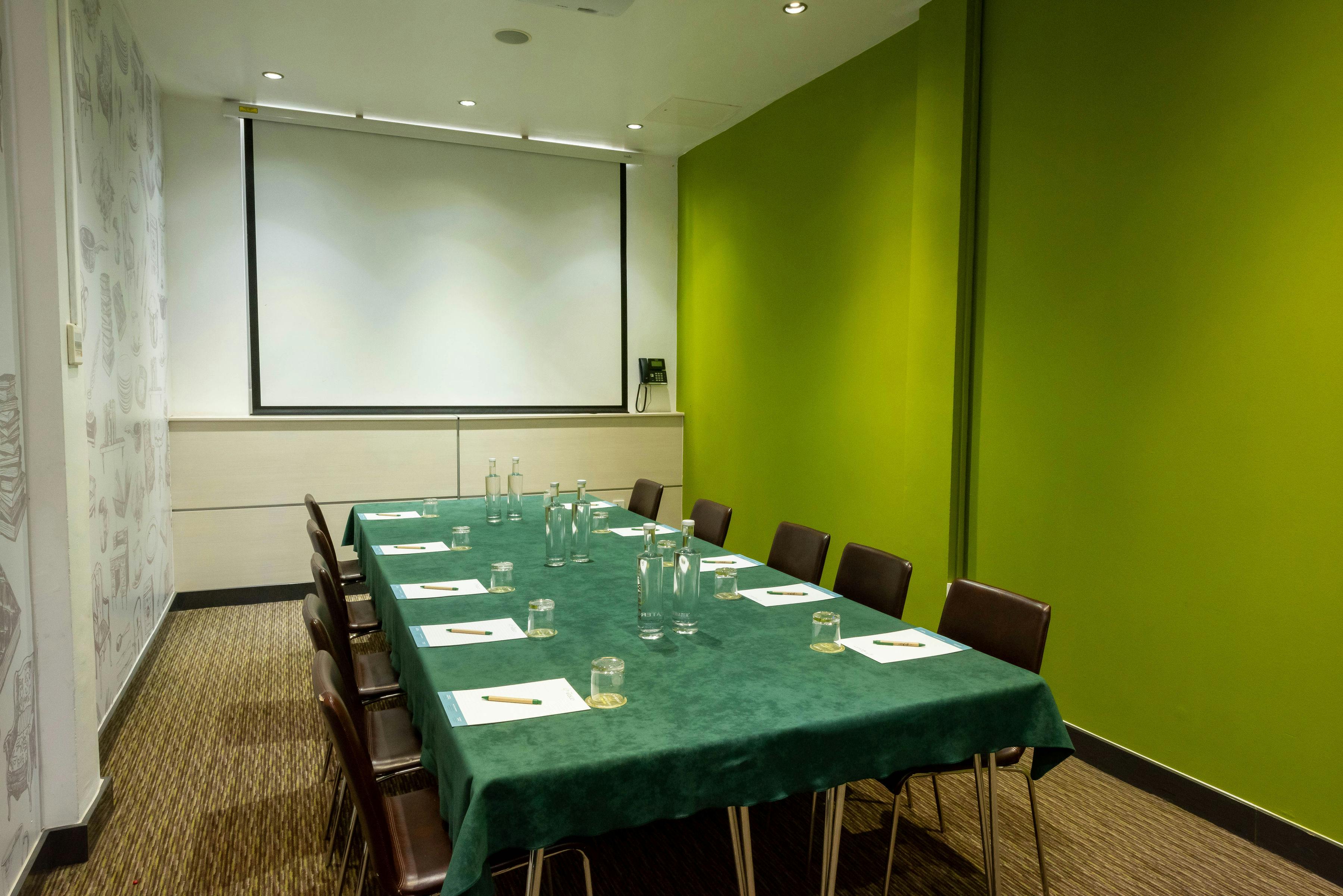 Meeting room in The Wesley Euston Hotel with long table, ideal for workshops and presentations.