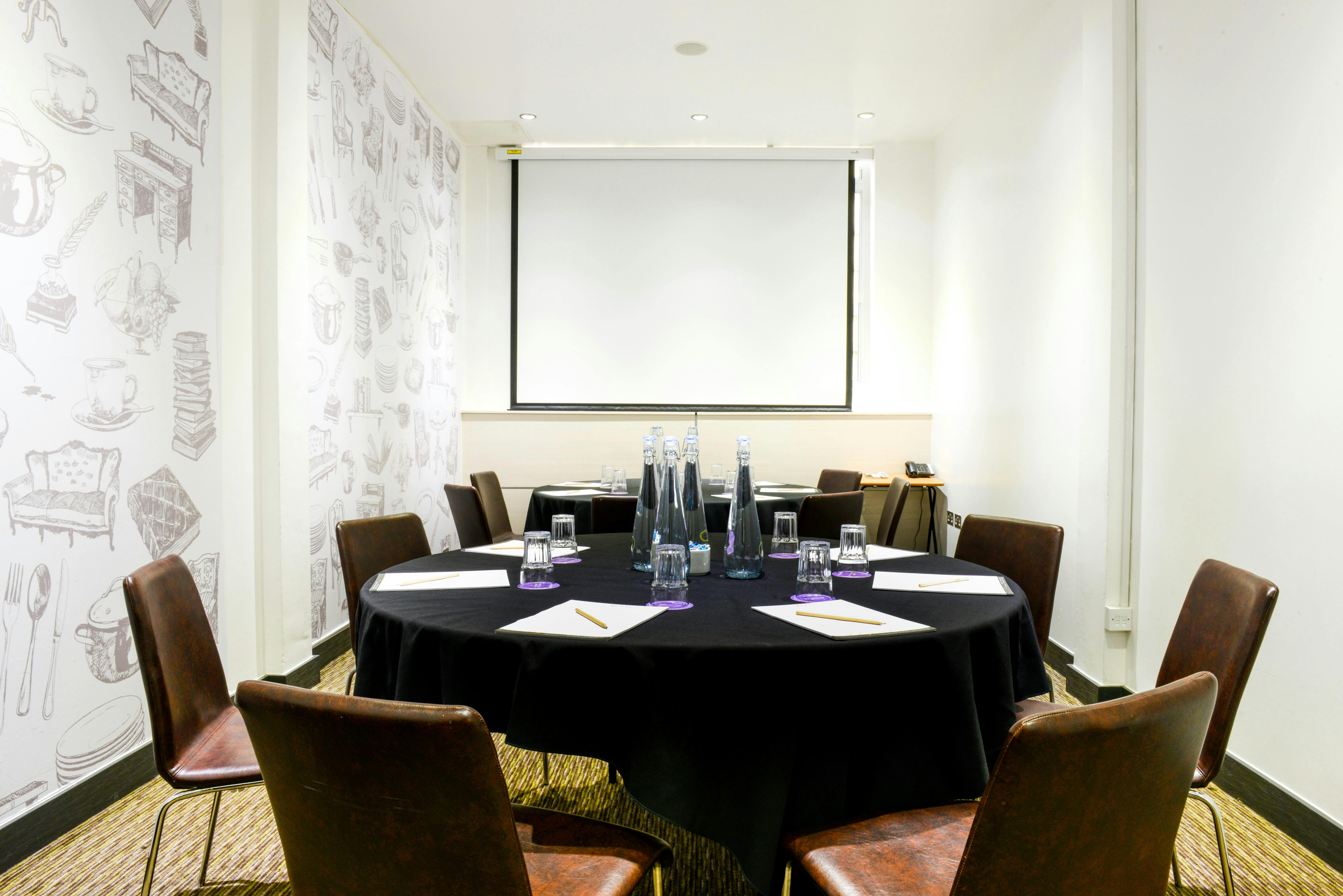 Elegant meeting room with round table setup at The Wesley Euston Hotel for conferences.